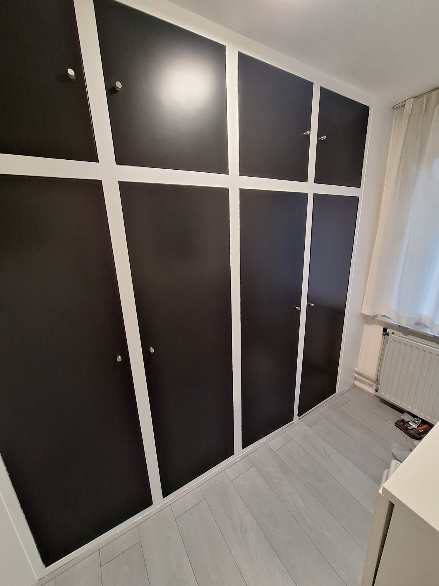 Donker afgewerkte kastdeuren met witte omlijsting na het schilderwerk